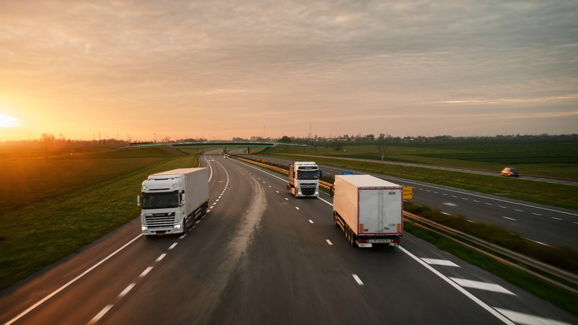 Semi-truck on the motorway at golden hour with mountains in the distance