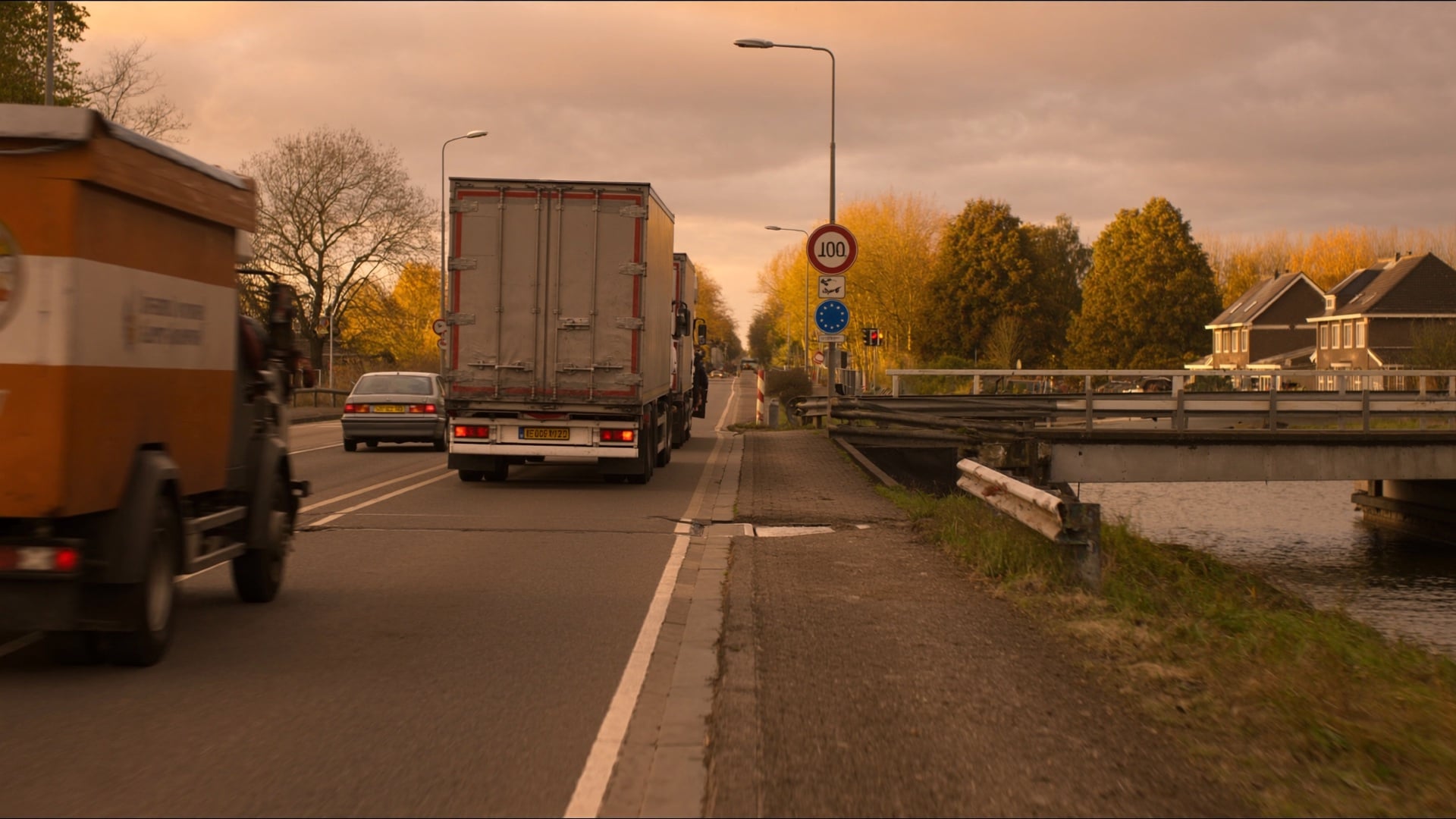 A low-clearance overpass bridge on a motorway with warning signs